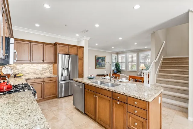 a kitchen with kitchen island granite countertop wooden cabinets a stove a sink a dining table and chairs