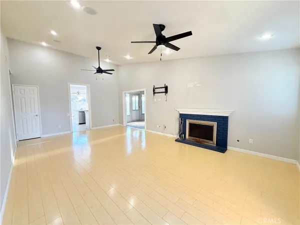 a view of empty room with wooden floor and fireplace