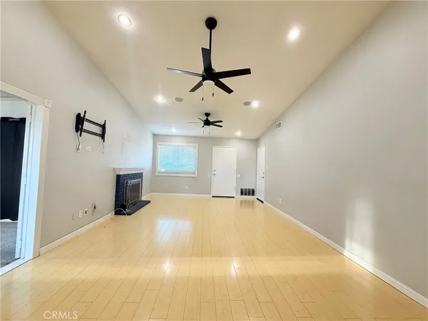 a big room with chandelier fan and windows