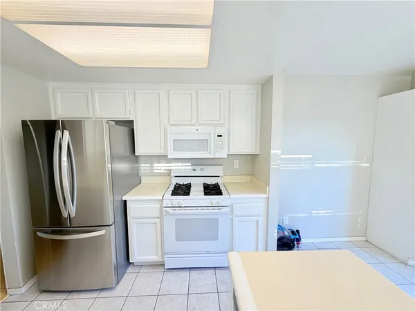 a kitchen with a refrigerator sink and cabinets