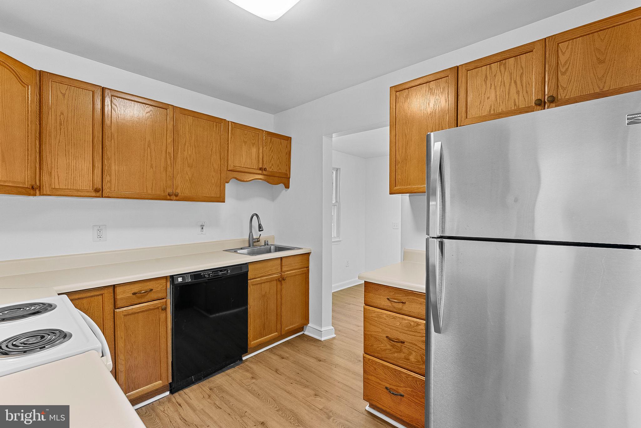 3103 Plyers Mill Road Kensington, MD 20895 - Photo 13 of 32 a kitchen with a refrigerator sink and cabinets