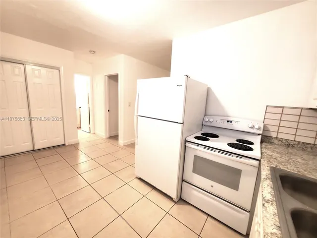 a kitchen with a stove top oven and white cabinets
