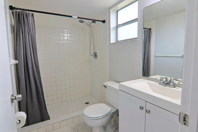 an empty room with a bathroom and a window