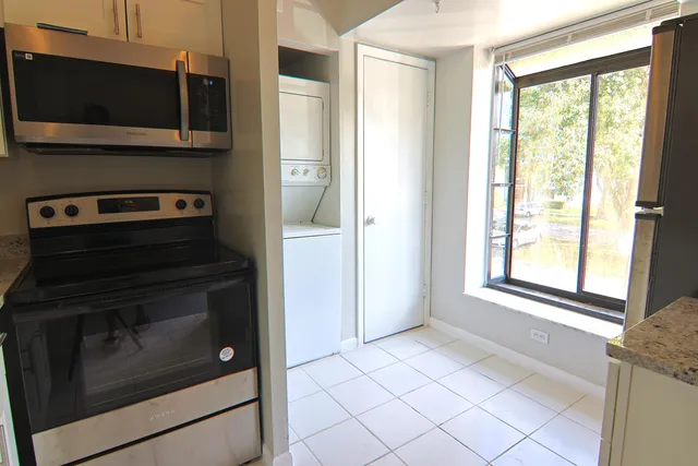 a kitchen with granite countertop cabinets stainless steel appliances and a window