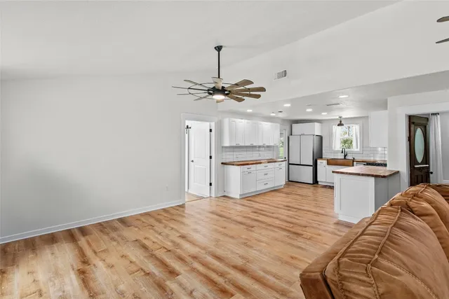 a view of a kitchen with kitchen island a sink stainless steel appliances and cabinets