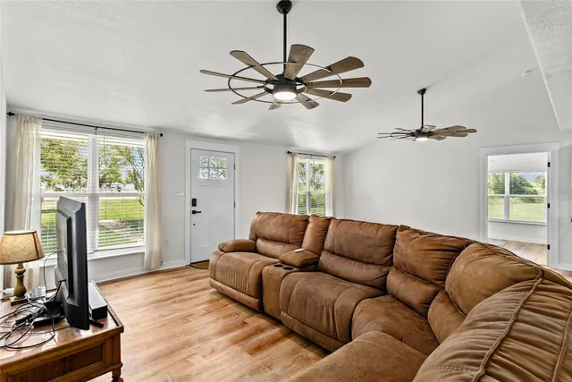 a living room with furniture ceiling fan and a window