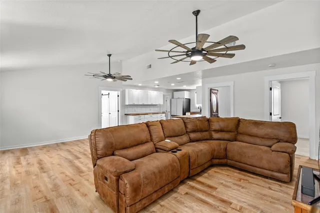a living room with furniture a ceiling fan and a rug