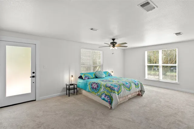 a bedroom with a bed a chandelier and a window
