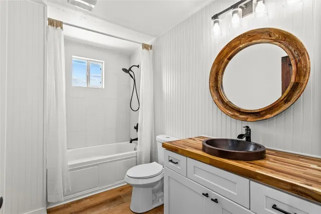 a view of a white house with a big yard and large trees