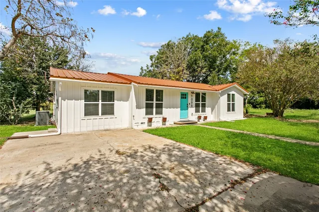 a view of a house with yard and tree s