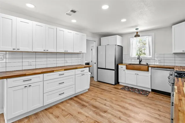 a kitchen with granite countertop white cabinets and white appliances