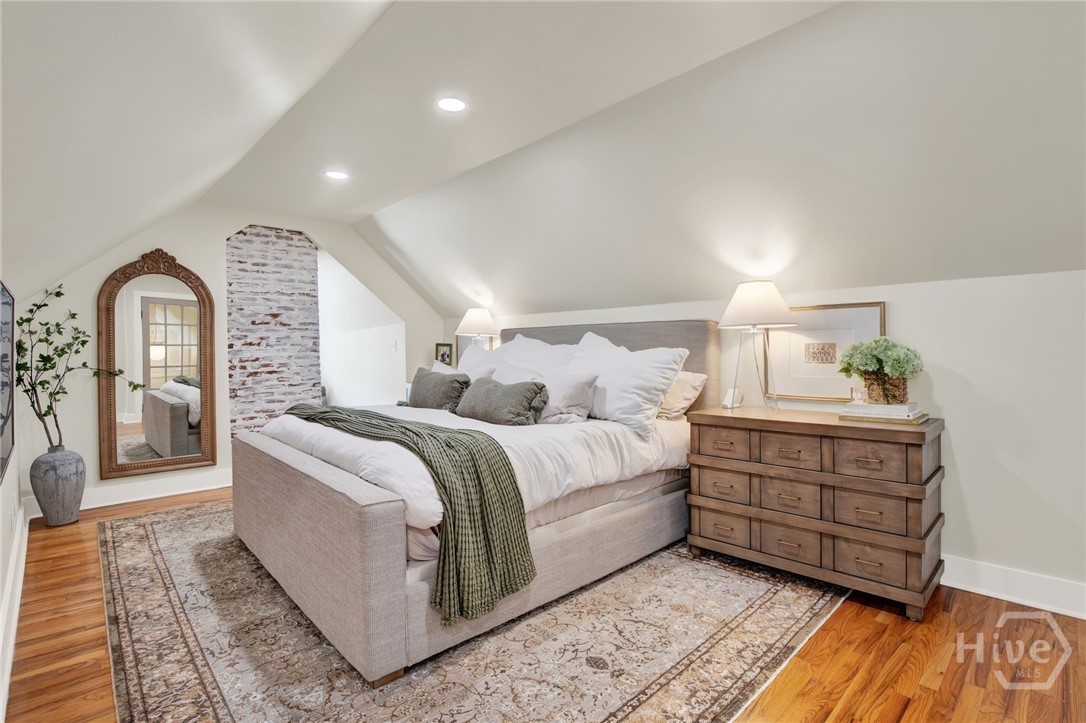 208 East 48th Street Savannah, GA 31405 - Photo 36 of 50 Third floor master bedroom with exposed brick wall. Vaulted ceiling with cove lighting.