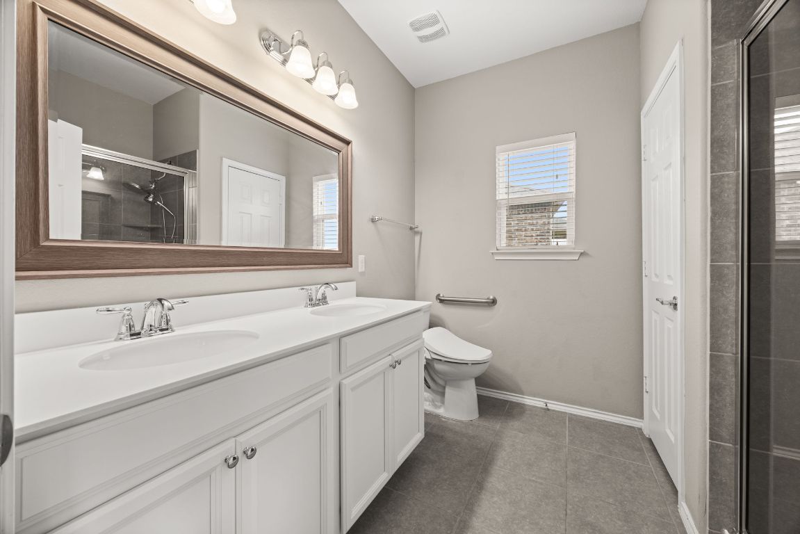 125 Hopen Cove Leander, TX 78641 - Photo 11 of 20 a bathroom with a toilet sink and mirror