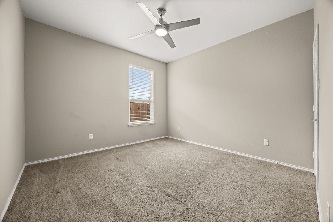 125 Hopen Cove Leander, TX 78641 - Photo 14 of 20 an empty room with a ceiling fan and a window