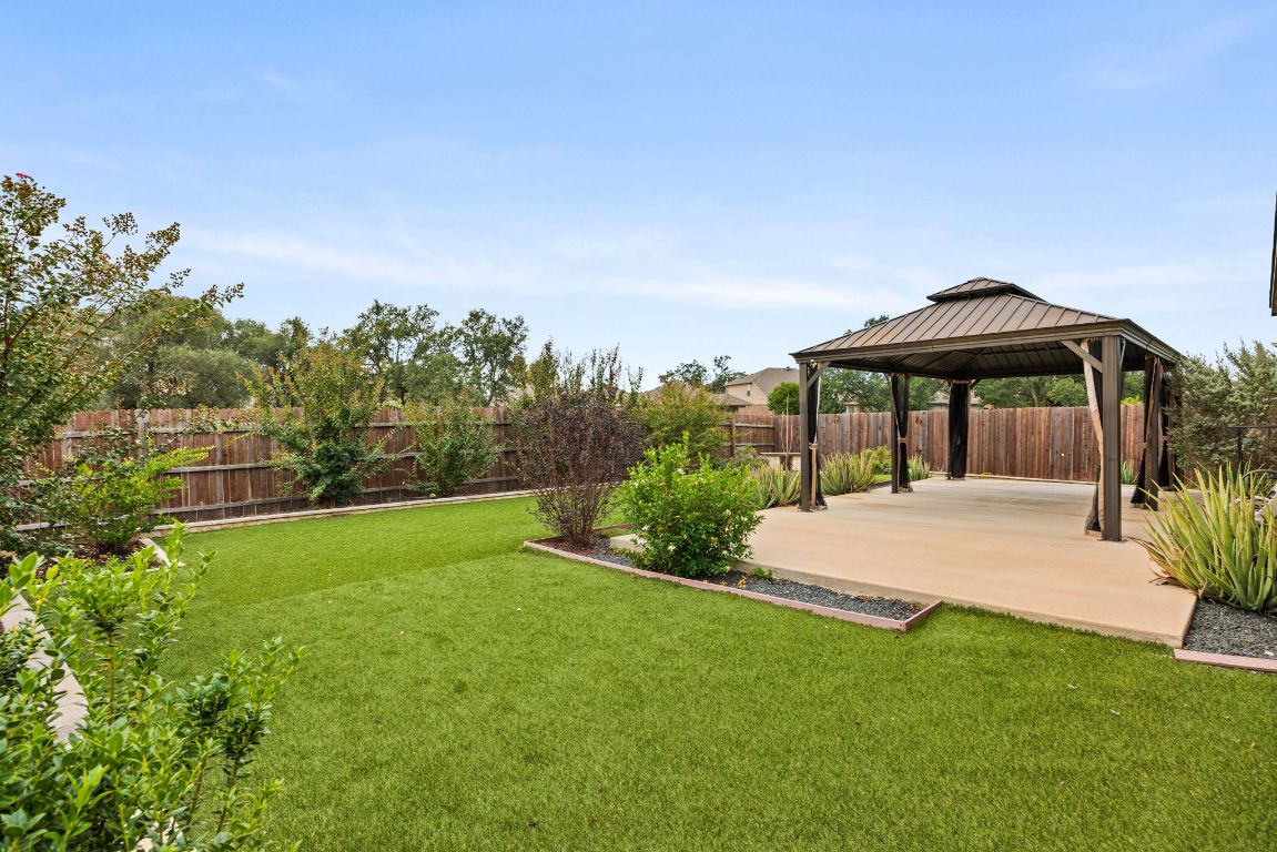 125 Hopen Cove Leander, TX 78641 - Photo 18 of 20 a patio with a table and chairs under an umbrella