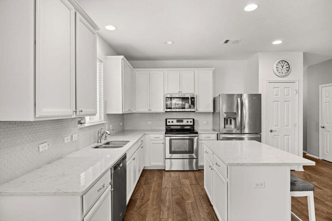 125 Hopen Cove Leander, TX 78641 - Photo 5 of 20 a kitchen with stainless steel appliances sink stove refrigerator and cabinets
