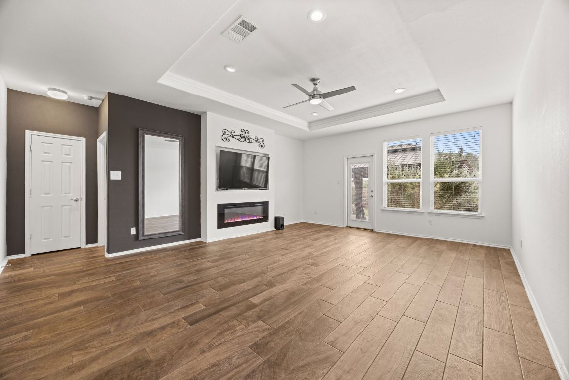 125 Hopen Cove Leander, TX 78641 - Photo 7 of 20 a view of an empty room with a window and wooden floor