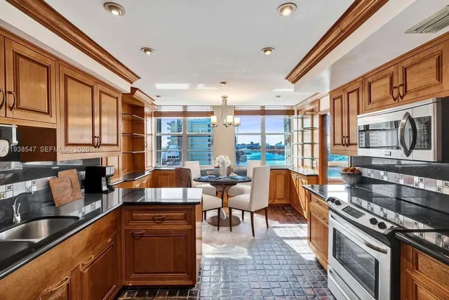 a kitchen with stainless steel appliances granite countertop a stove a sink and a microwave