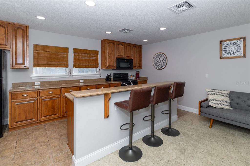 3305 Schoolhouse Road St. Cloud, FL 34773 - Photo 30 of 83 a kitchen with a sink a stove a refrigerator cabinets and furniture