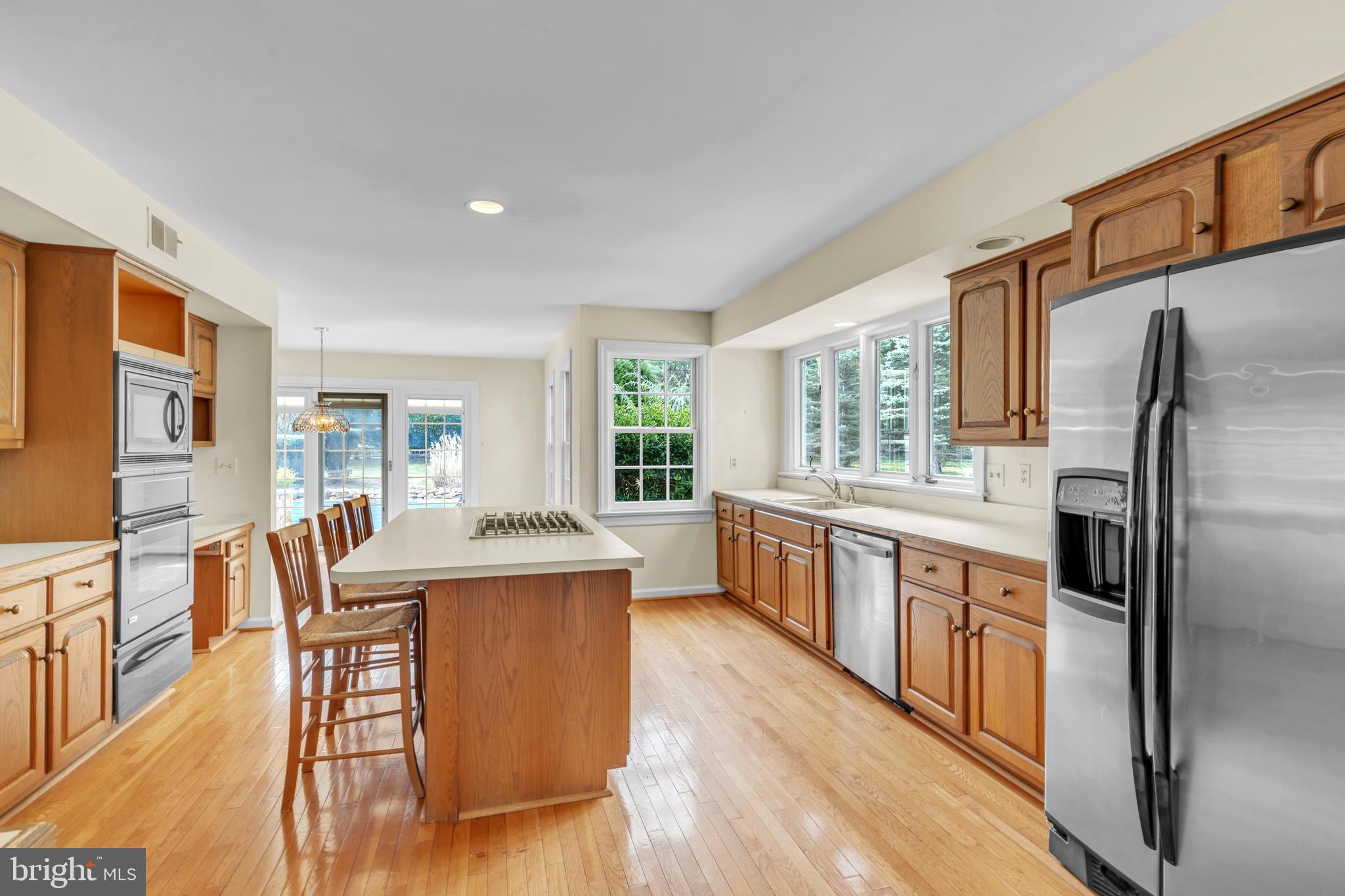 292 Church Road Devon, PA 19333 - Photo 6 of 21 a kitchen with stainless steel appliances granite countertop a refrigerator a stove top oven a sink dishwasher and white cabinets with wooden floor