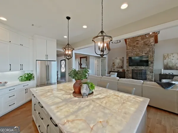 a kitchen with stainless steel appliances kitchen island granite countertop a table chairs and a wooden floor