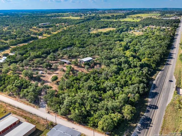 an aerial view of residential houses with outdoor space and trees
