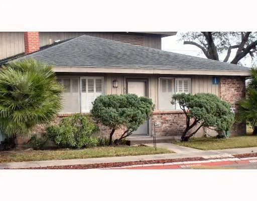 a front view of a house with a yard and potted plants