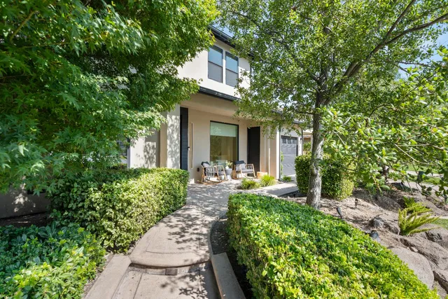 a front view of a house with yard and green space
