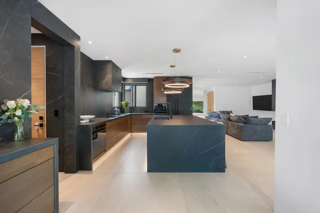 a kitchen with stainless steel appliances granite countertop a sink a stove and a refrigerator