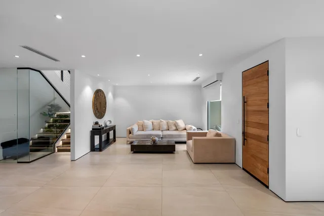 a living room with furniture and a mirror