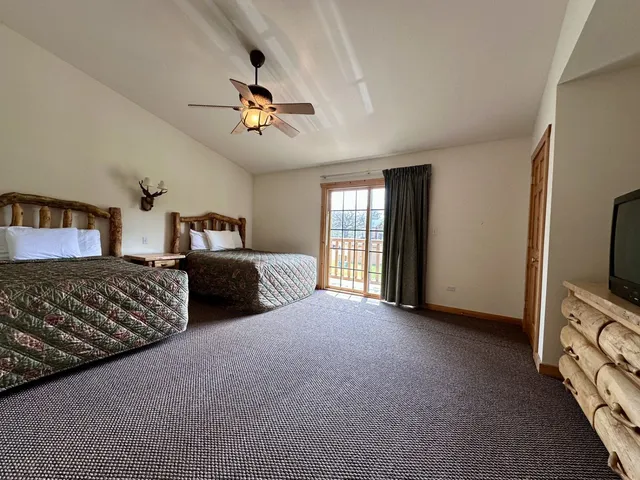 a spacious bedroom with a bed and a flat screen tv