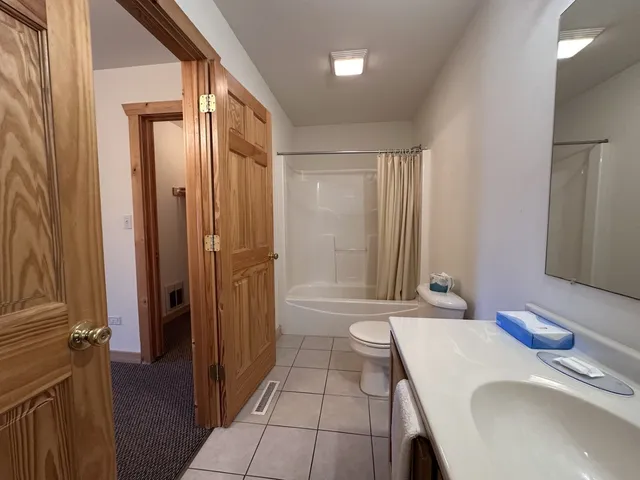 a bathroom with a granite countertop sink a mirror and a bathtub