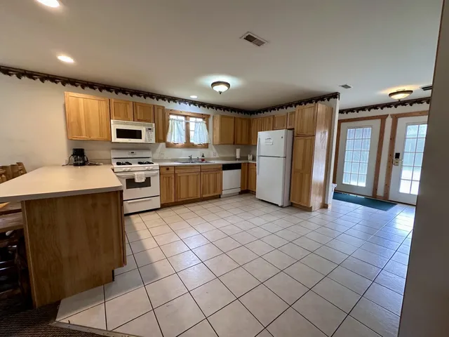 a kitchen with a sink a refrigerator and cabinets