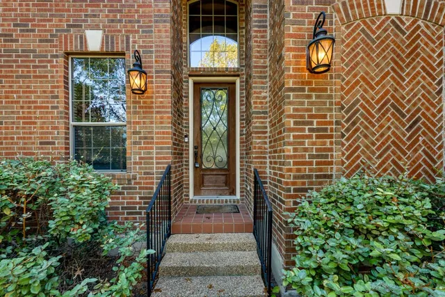 an empty room with wooden floor fireplace and windows