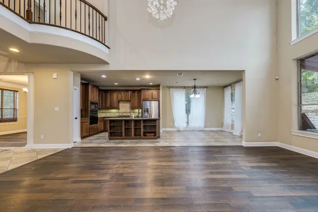 a view of a room with wooden floor chandelier and windows
