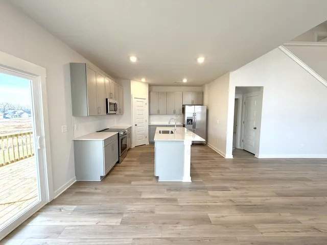 a large kitchen with a lot of counter space and wooden floor