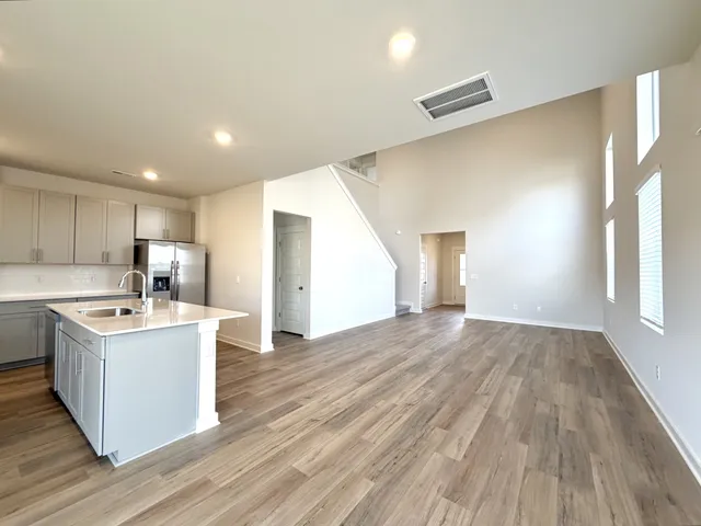 a large kitchen with a large counter top a sink stainless steel appliances and cabinets