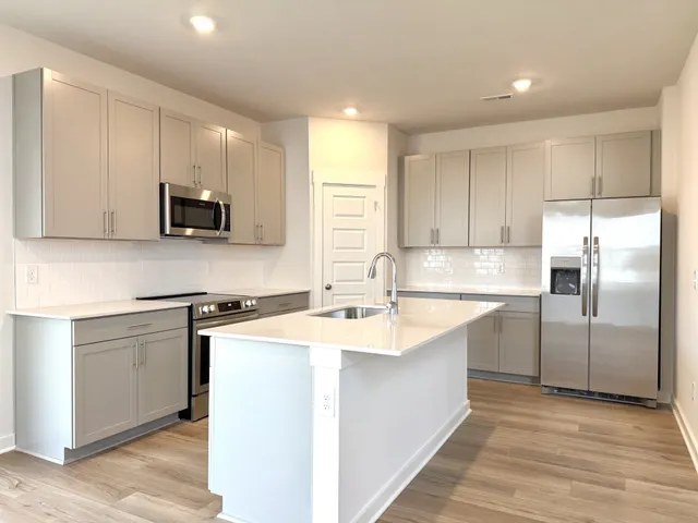 a kitchen with kitchen island a sink stove and refrigerator