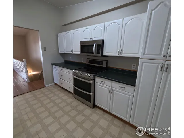 a kitchen with stainless steel appliances granite countertop a stove a microwave and a refrigerator