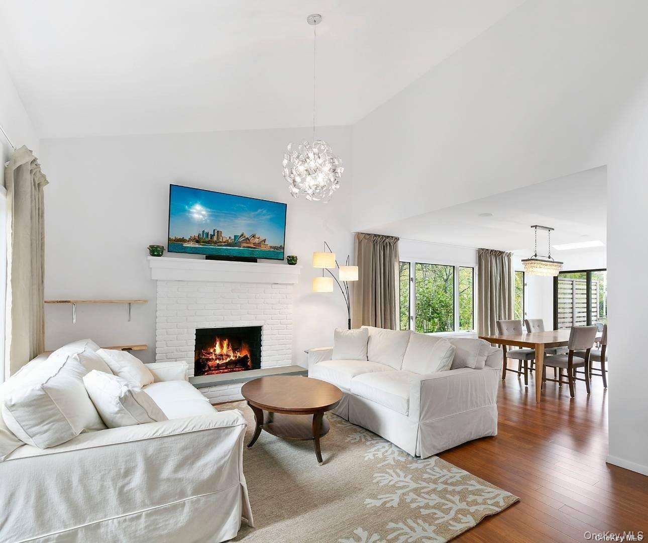 7 Harbor Road Hampton Bays, NY 11946 - Photo 4 of 22 a living room with furniture a flat screen tv and a fireplace
