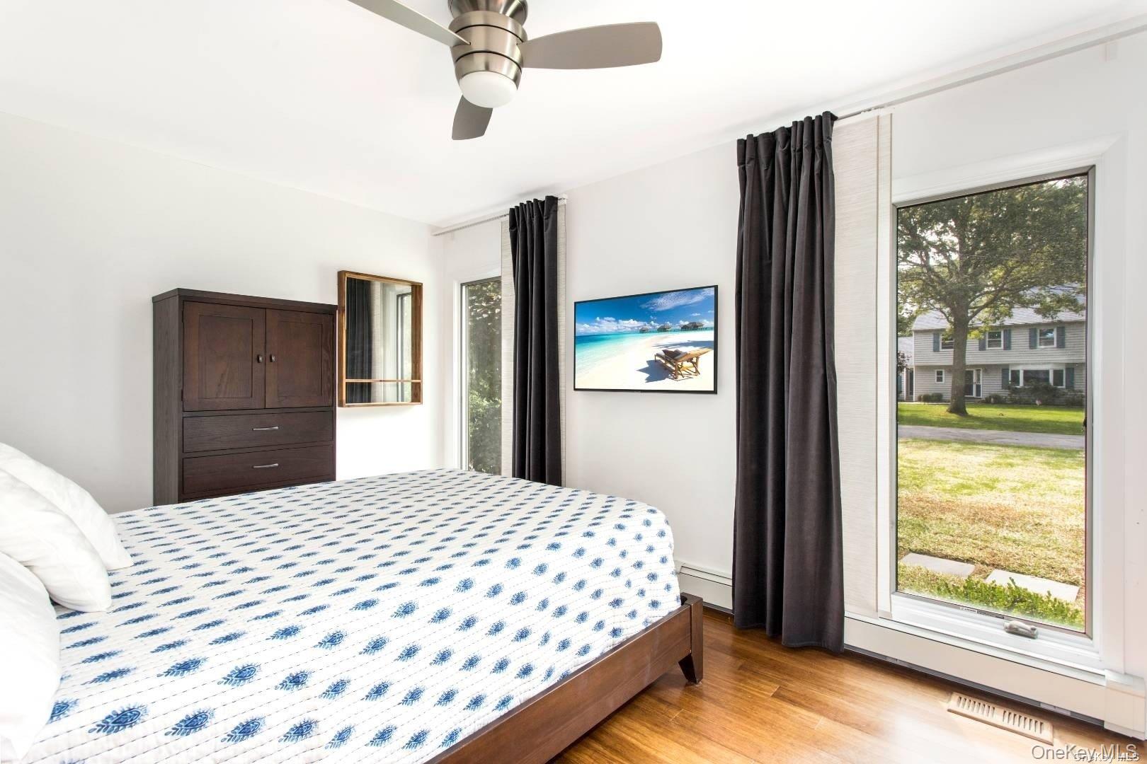 7 Harbor Road Hampton Bays, NY 11946 - Photo 9 of 22 a bedroom with a large bed and a window