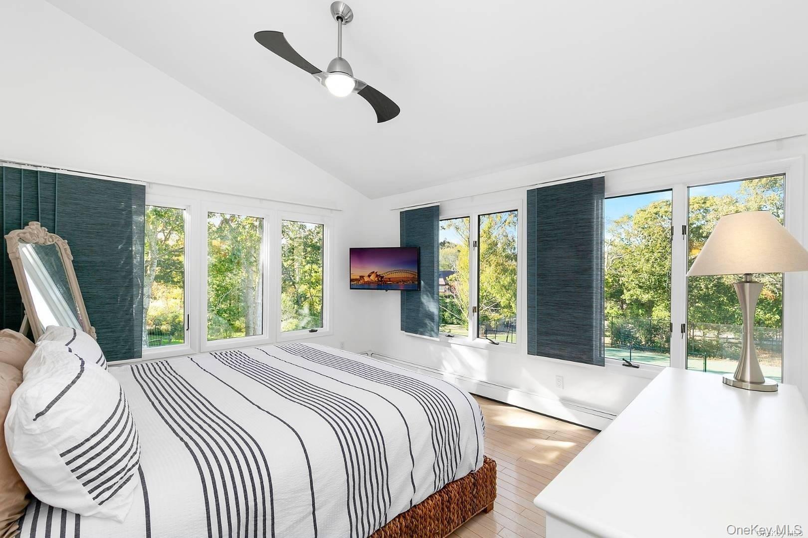 7 Harbor Road Hampton Bays, NY 11946 - Photo 10 of 22 a bedroom with a bed a large window with table and chairs