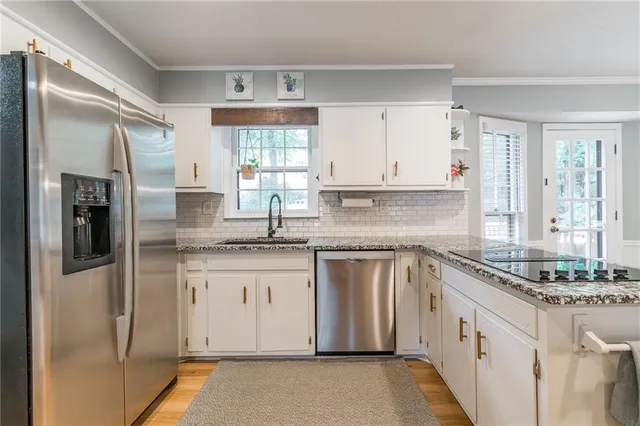 a kitchen with granite countertop stainless steel appliances a sink stove and refrigerator