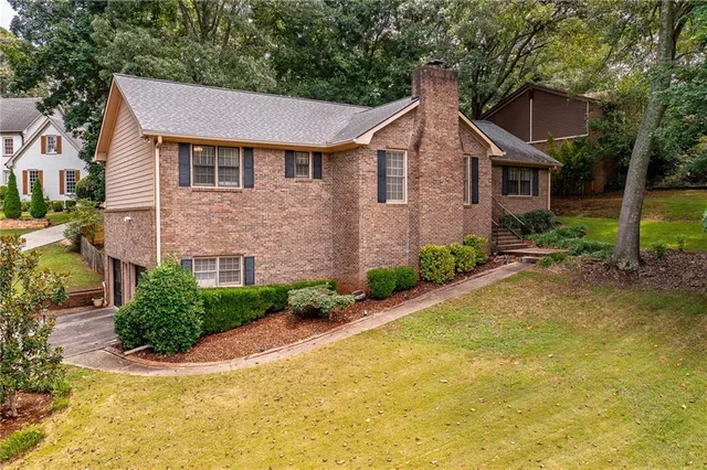 a front view of a house with a yard and trees