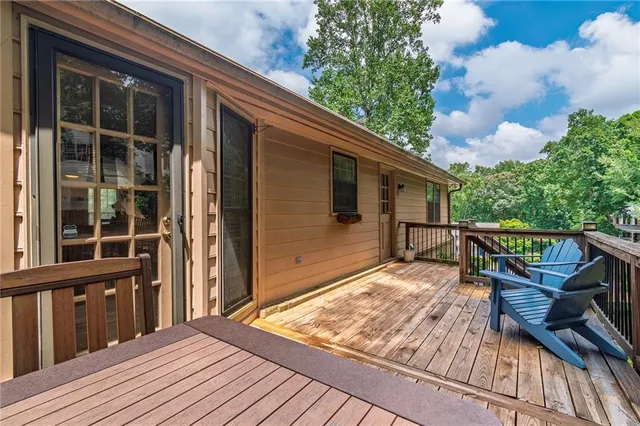 a balcony with wooden floor and outdoor seating