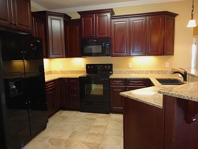 6787 Maple Springs Road Manchester, TN 37355 - Photo 5 of 20 The kitchen with granite, bar seating, granite composite sink, tile flooring and under cabinet lighting. All appliances remain.