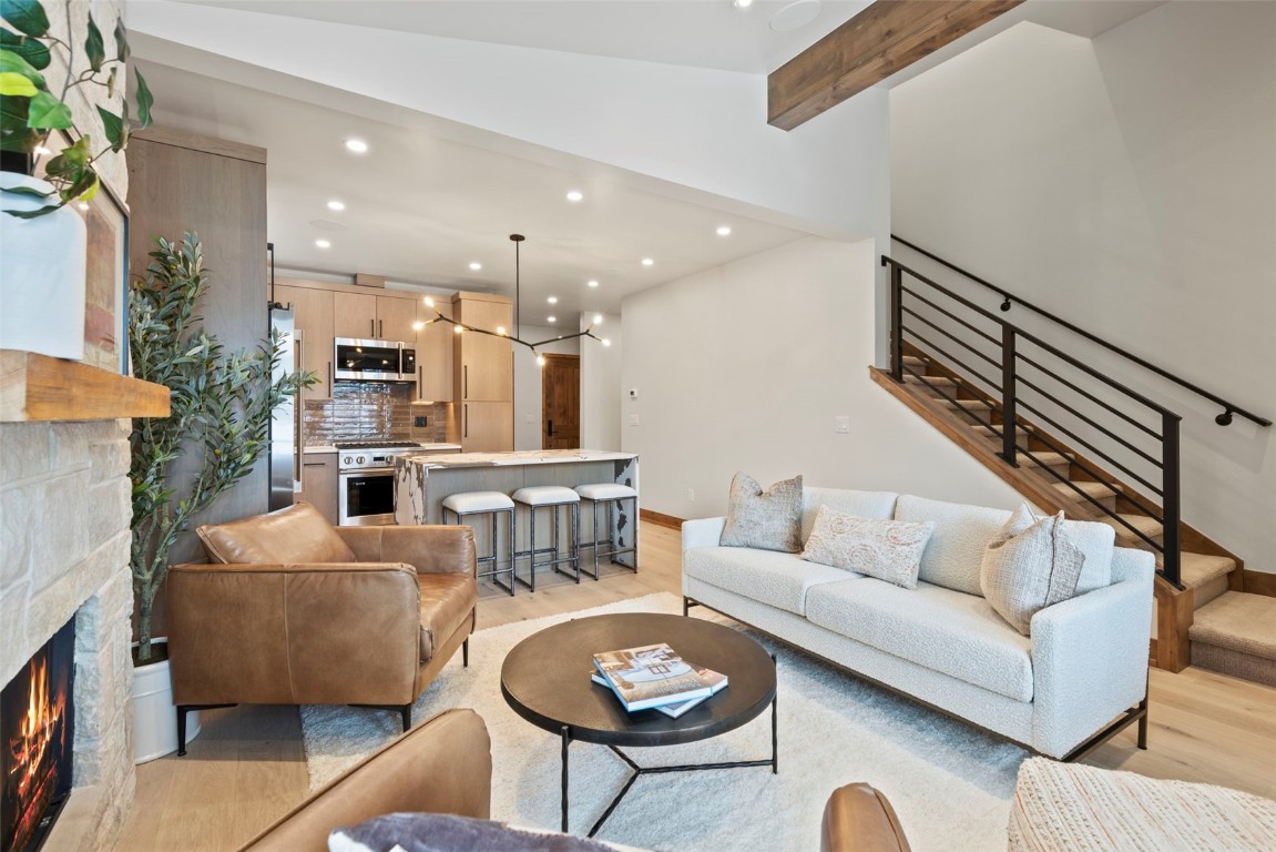 203 North Ridge Street, Unit B Breckenridge, CO 80424 - Photo 10 of 49 Living room with recessed lighting, a stone fireplace, light wood-style floors, and stairs