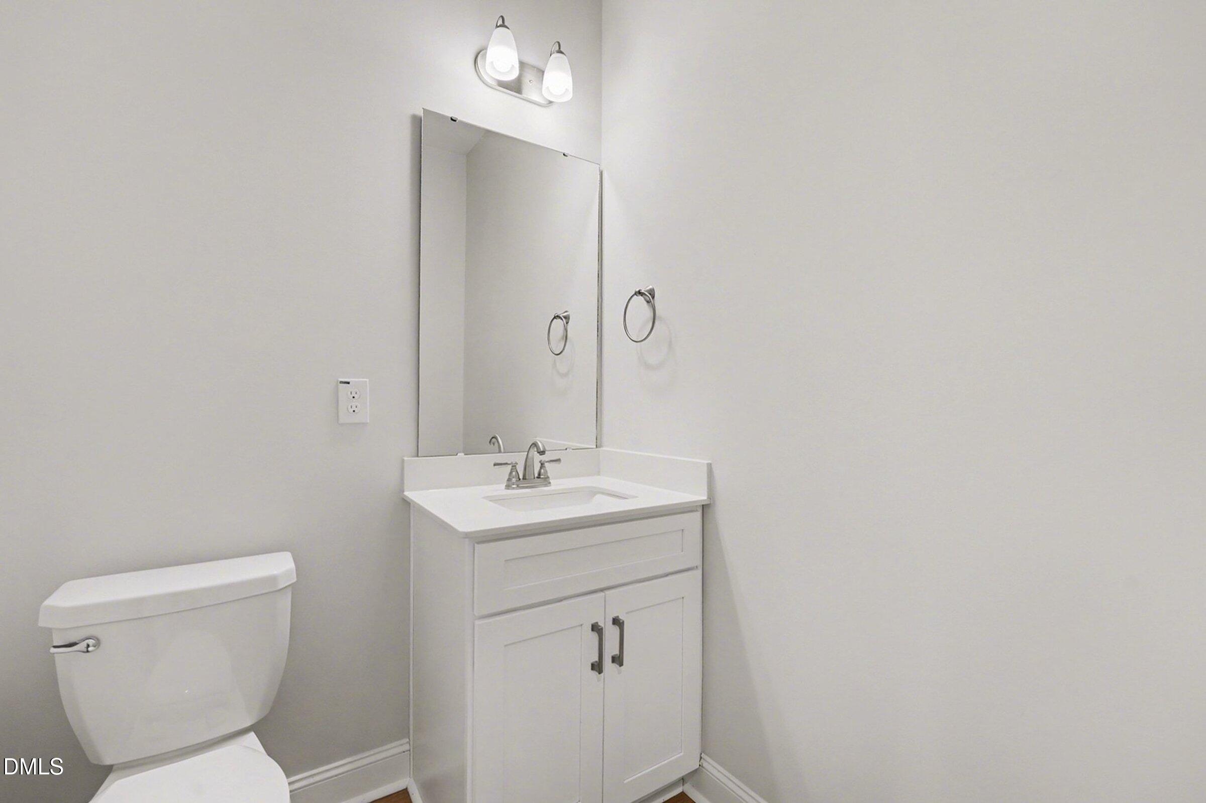 2815 Lemuel Black Road Spring Lake, NC 28390 - Photo 37 of 37 a bathroom with a toilet a sink and mirror