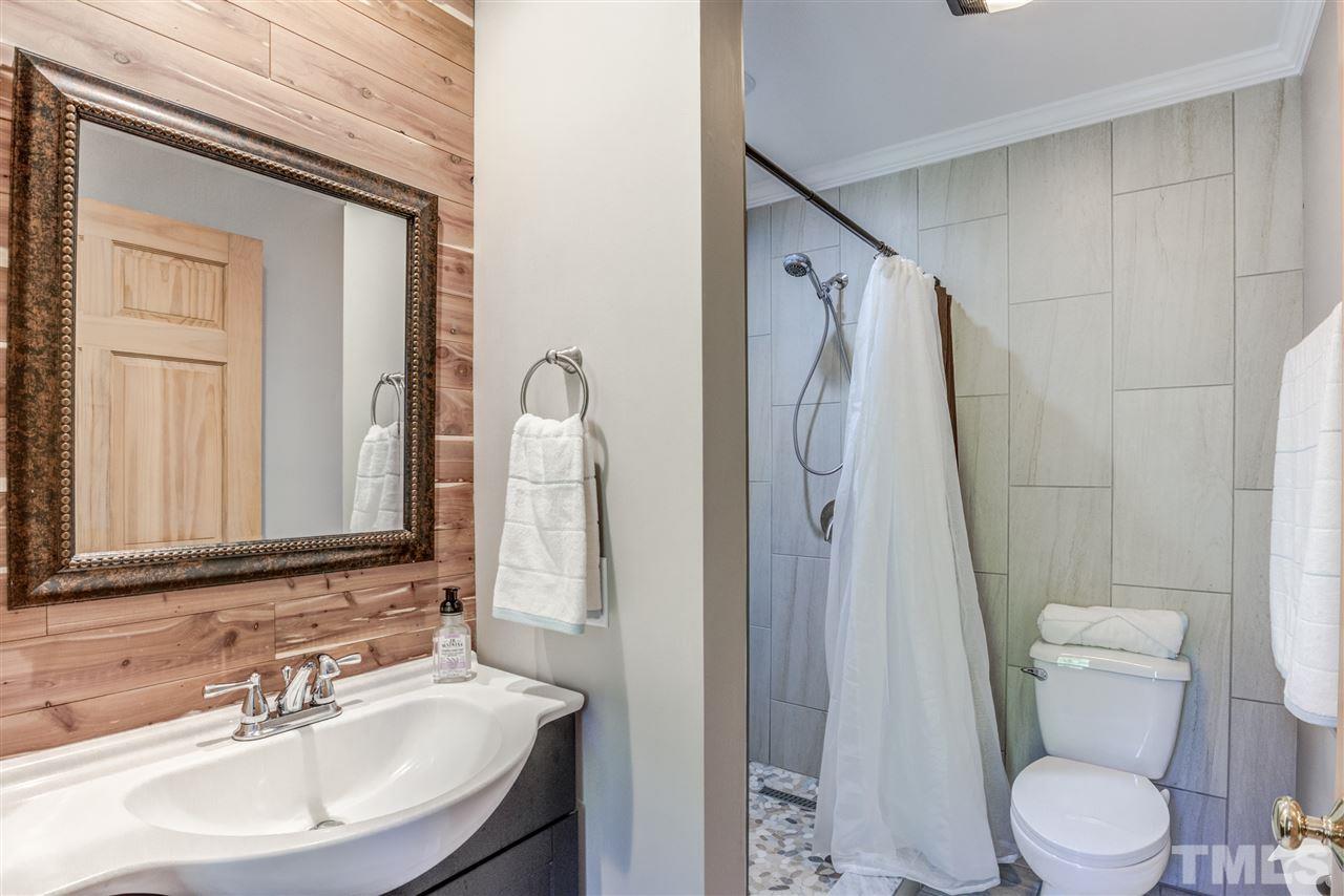 9554 Valley Road Middlesex, NC 27557 - Photo 23 of 30 a bathroom with a sink a toilet a mirror and shower