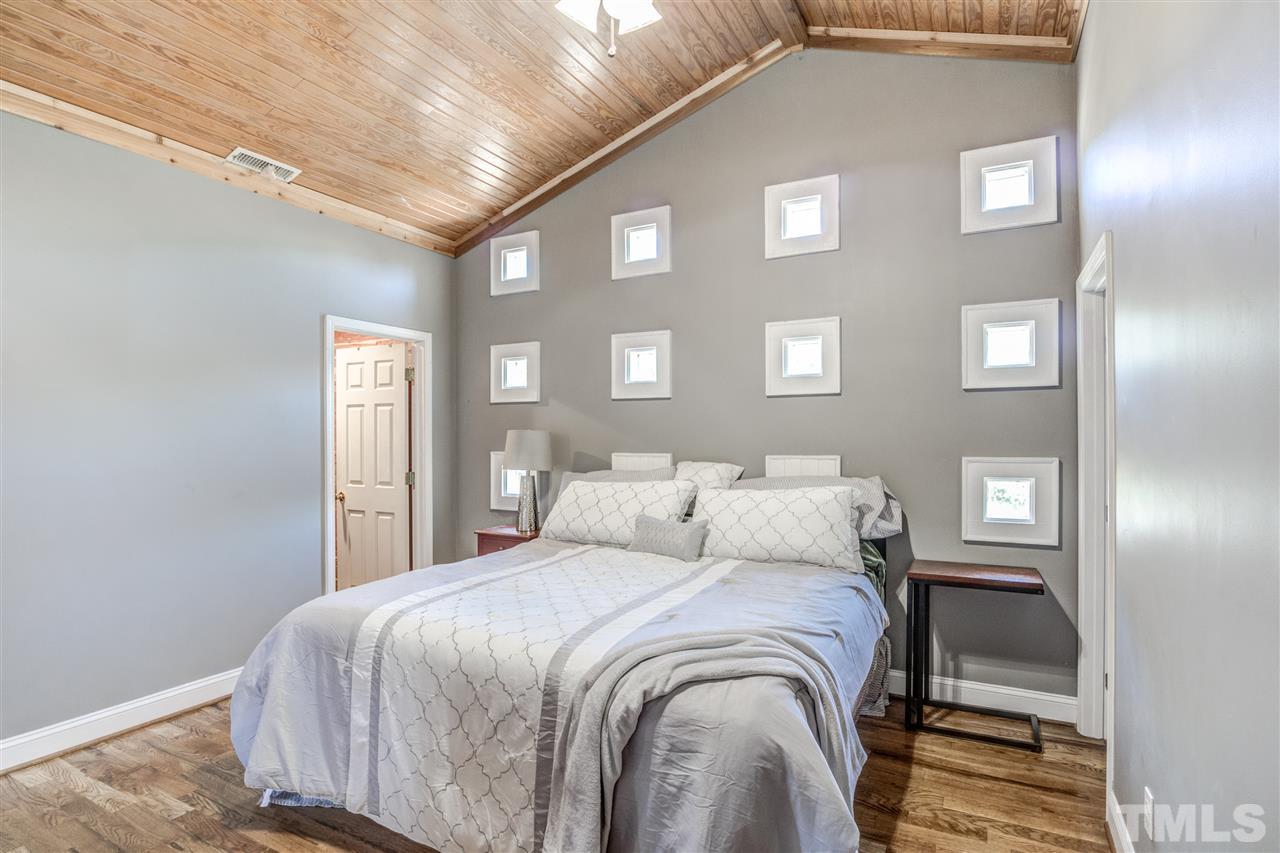 9554 Valley Road Middlesex, NC 27557 - Photo 24 of 30 a bedroom with a bed and mirror
